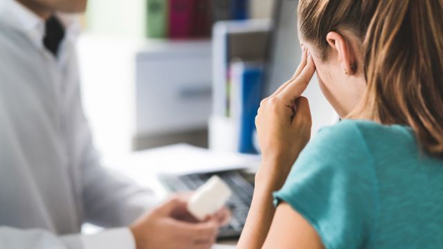 Woman discussing migraine symptoms with doctor