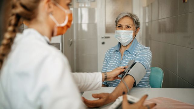 A healthcare provider takes a patient's blood pressure during a checkup.