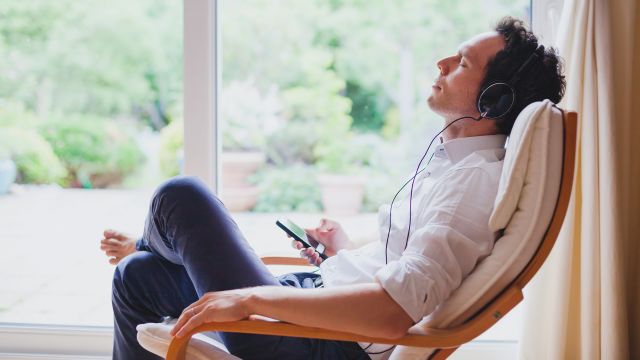 A man, relaxed and calm, listens to music