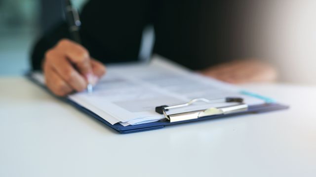 A patient fills out insurance paperwork