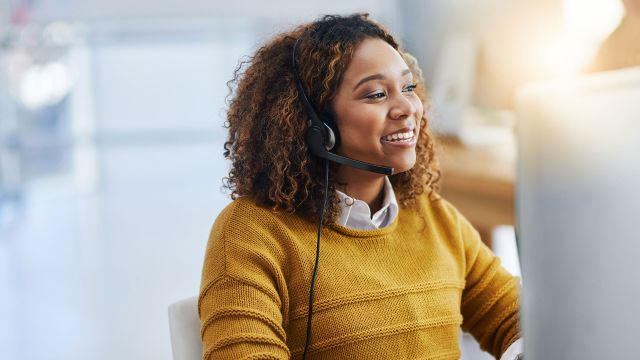 Young working in a call center, smiling.