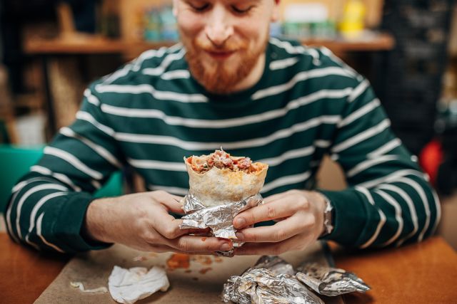 man eating big bean burrito