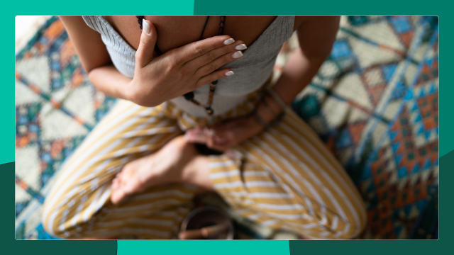woman meditating on a colorful rug.