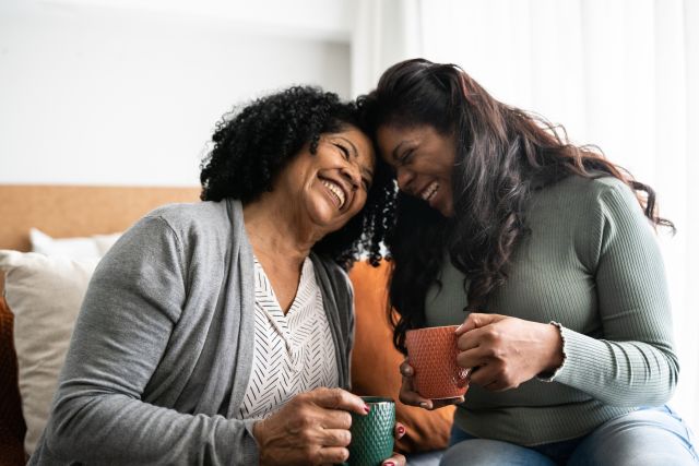 mom and daughter laughing over coffee