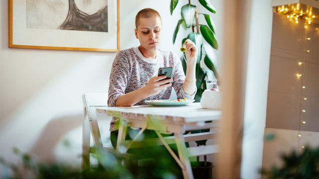 Cancer patient looks at phone.