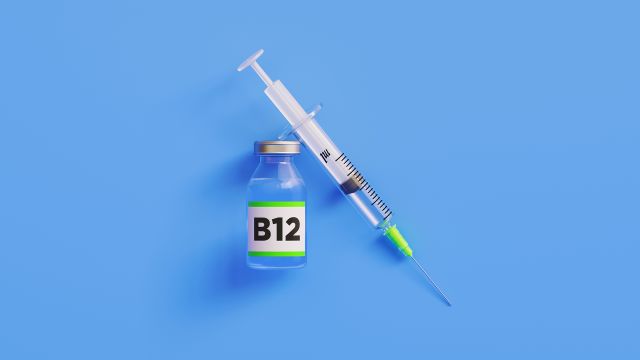 A syringe full of vitamin B12 on a blue background.