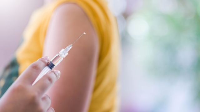 A teenage girl receives a vaccination. The preferred age range for MenB vaccination is between 16 and 18 years old.