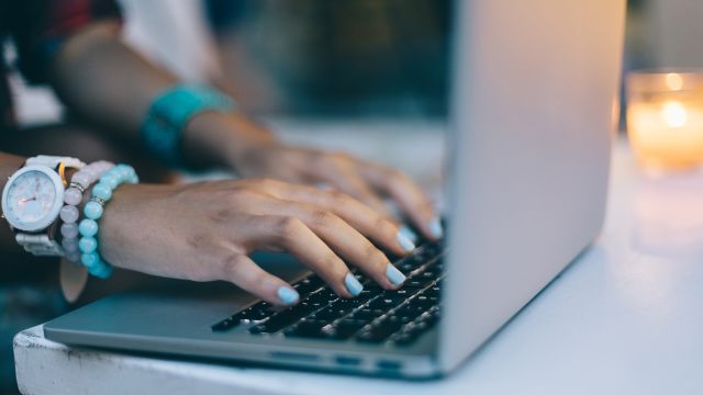 A young woman typing on her computer.