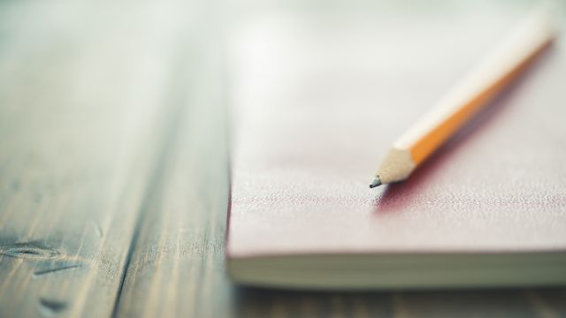 A journal and pencil. Keeping a journal of symptoms and what you eat can be helpful when managing UC.