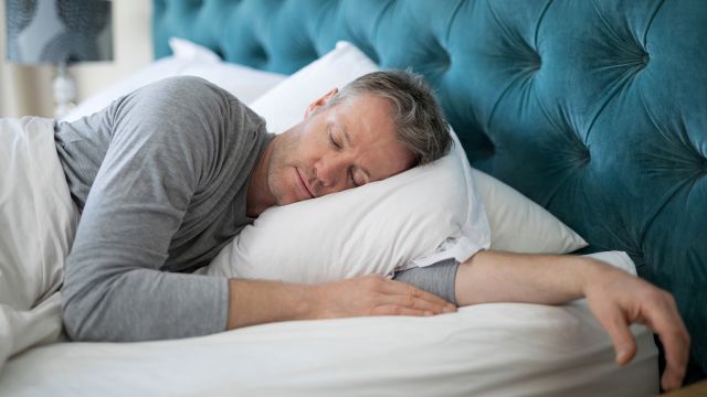 Man sleeps restfully in bed.