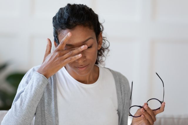 Head shot young stressed unhappy woman taking off eyeglasses, feeling tired of long computer work or suffering Rheumatoid Arthritis