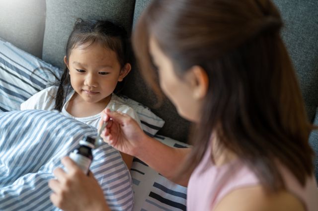 mother gives daughter medicine