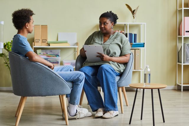 A young woman with bipolar disorder speaks with a counselor. Treatment for bipolar disorder can involve several healthcare providers working as a team.