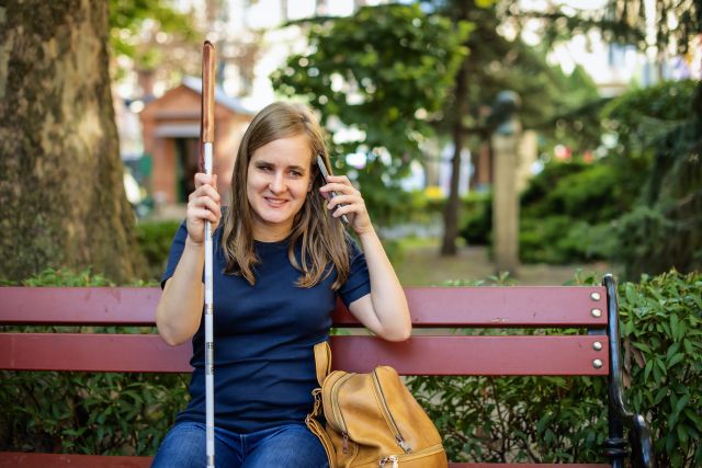 A young woman who has experienced vision loss enjoys a day outside at a park. Vision rehabilitation can help a person living with vision loss maintain independence and quality of life.