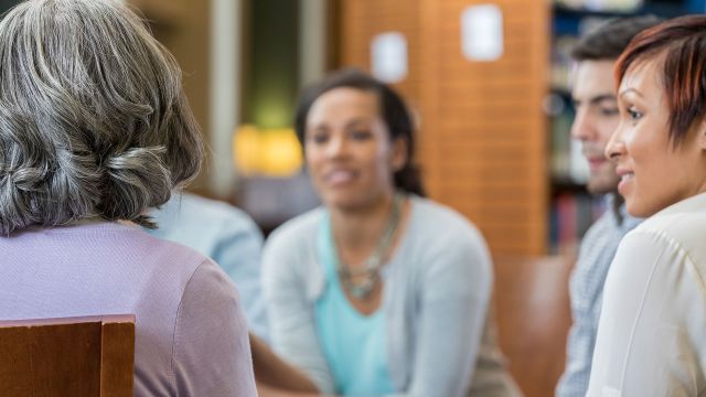 A group of women talking during a metastatic breast cancer support group meeting.