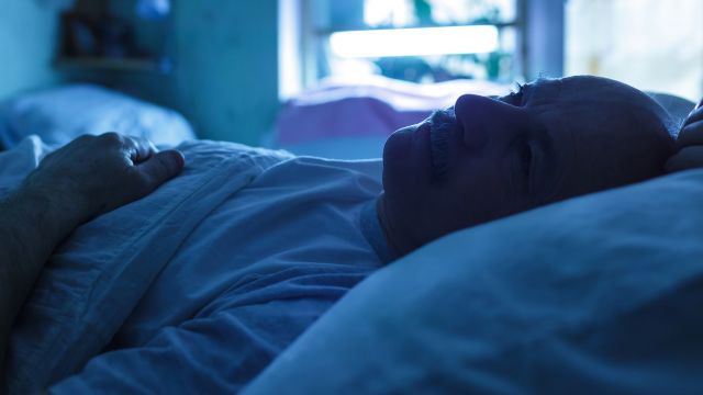 A man lies in bed to cope with the mental stress of a lung cancer diagnosis.