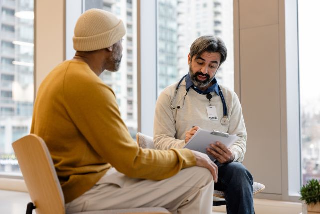 Someone sitting in a hospital and speaking with a healthcare provider