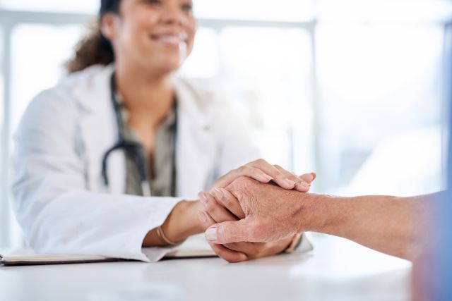 doctor and patient holding hands