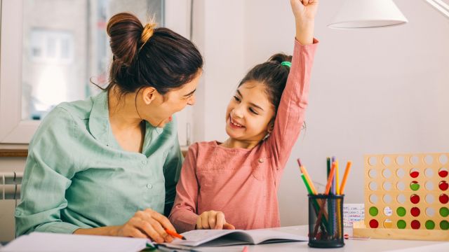 A mom and her grade school-age daughter complete an educational workbook about type 1 diabetes.