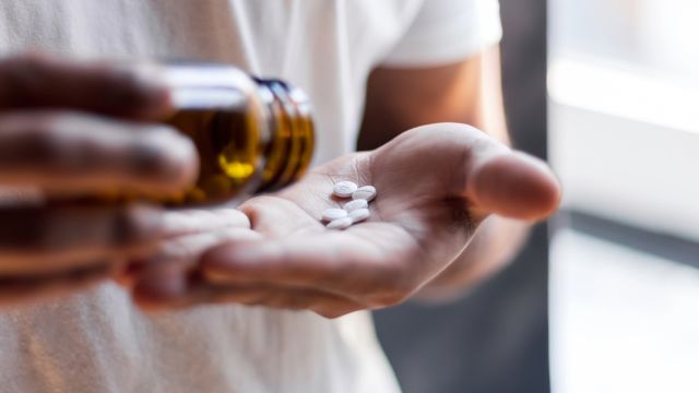 A man counts out his dose of glucocorticoid medication.