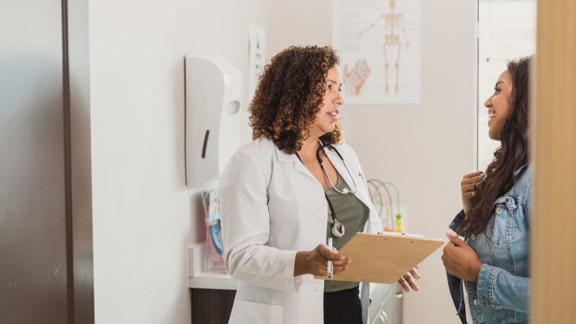 A Latin American woman meets with a new specialist to discuss treatment for multiple sclerosis.