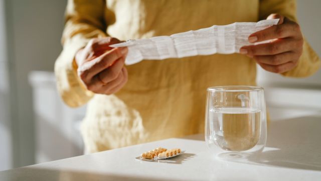 A woman reads the prescribing information for a medication. Treating Parkinson's disease psychosis may involve adjustments or changes to the medications a person is taking.