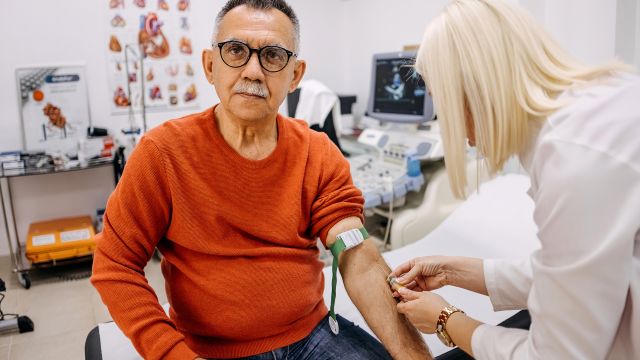 A senior-aged man receives a blood transfusion at a healthcare provider's office. Blood transfusions may be needed to treat anemia caused by myelofibrosis.