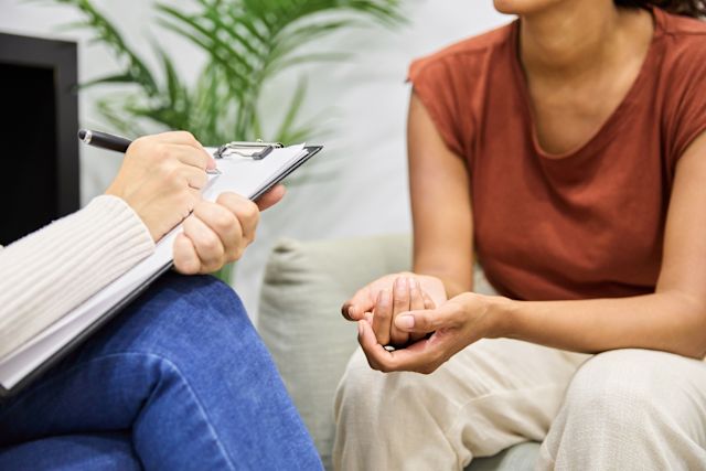 a young woman discusses treatment options for her mental health condition with a mental health professional