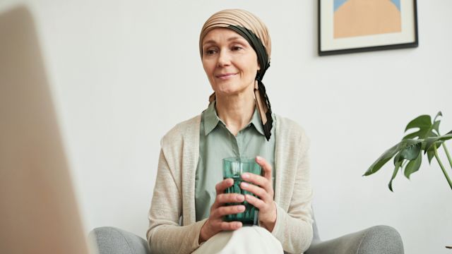A woman with endometrial cancer reads about treatment options and cancer care on a notebook computer.