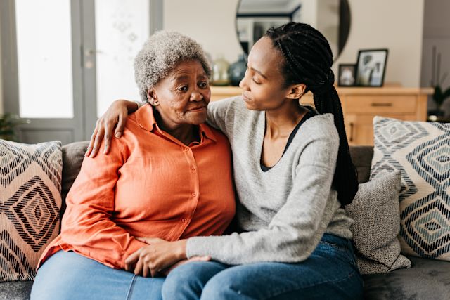 middle-aged daughter comforting depressed older mother