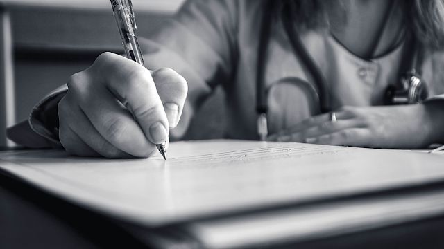 woman writing on a notepad