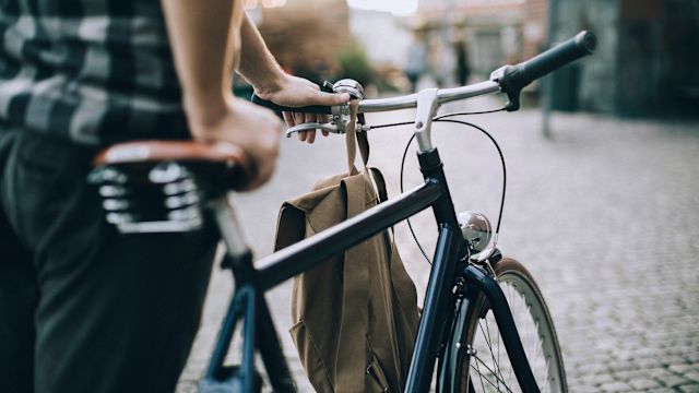 man standing with bicycle, close up