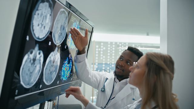 Opioid use can cause changes to the structure and composition of the brain. Two neurologists examine brain scans during a study involving people with OUD.