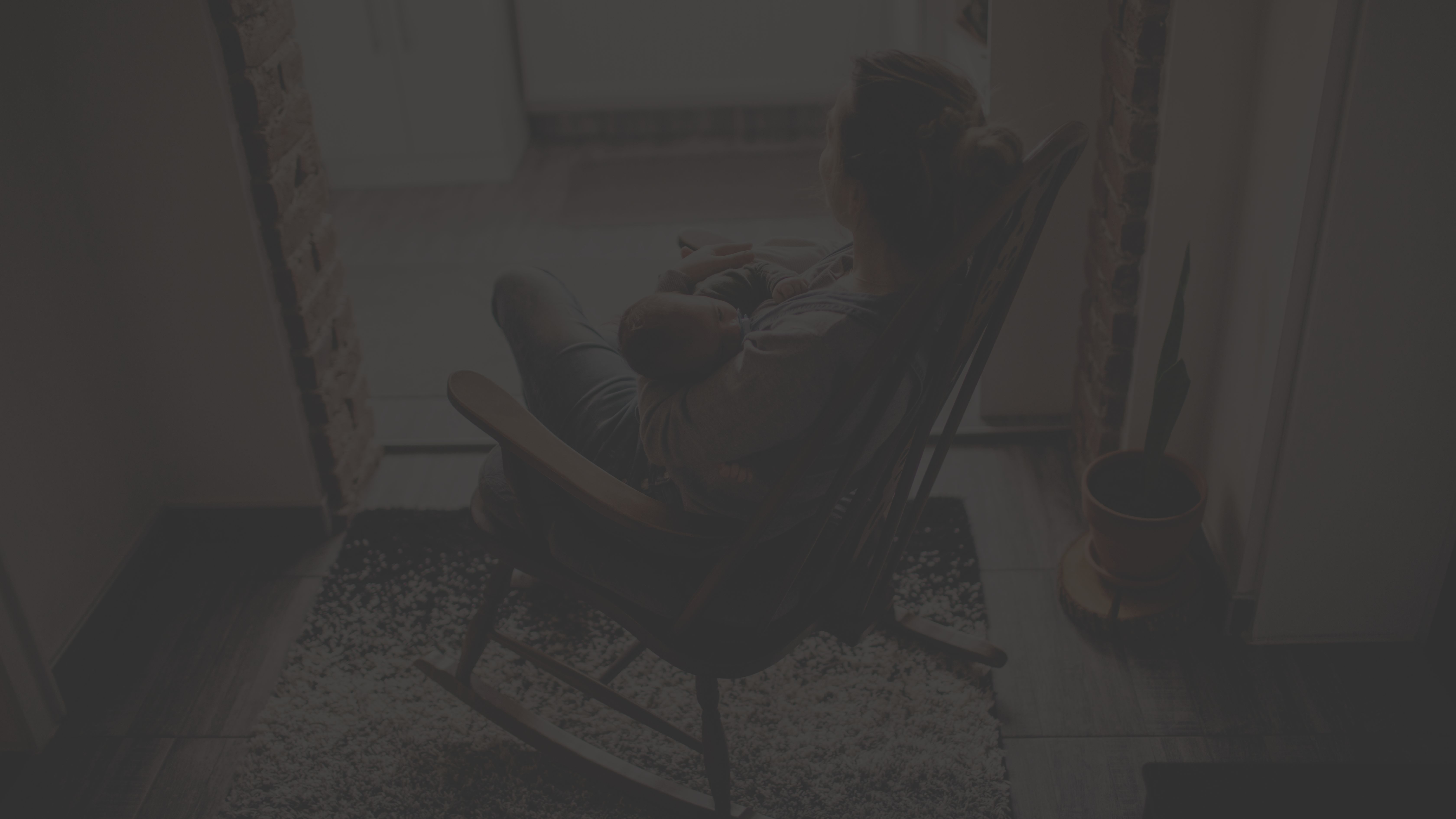 Someone holding newborn in rocking chair