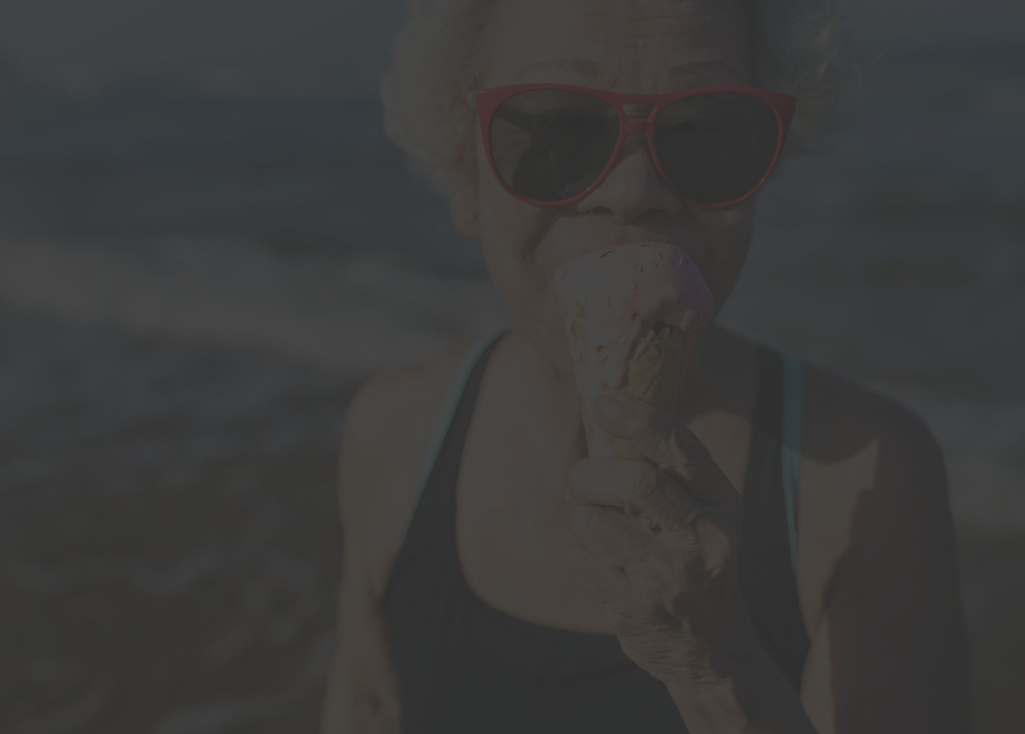 senior woman eating icecream on the beach