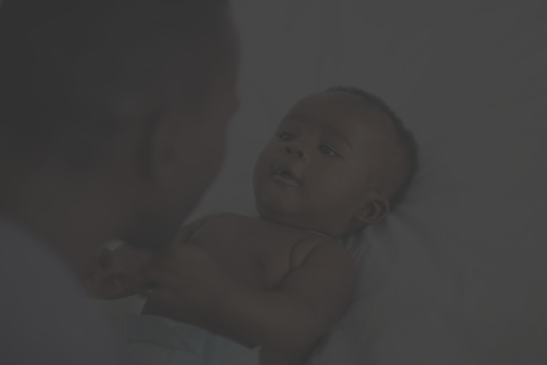 a Black man looks at his infant child 