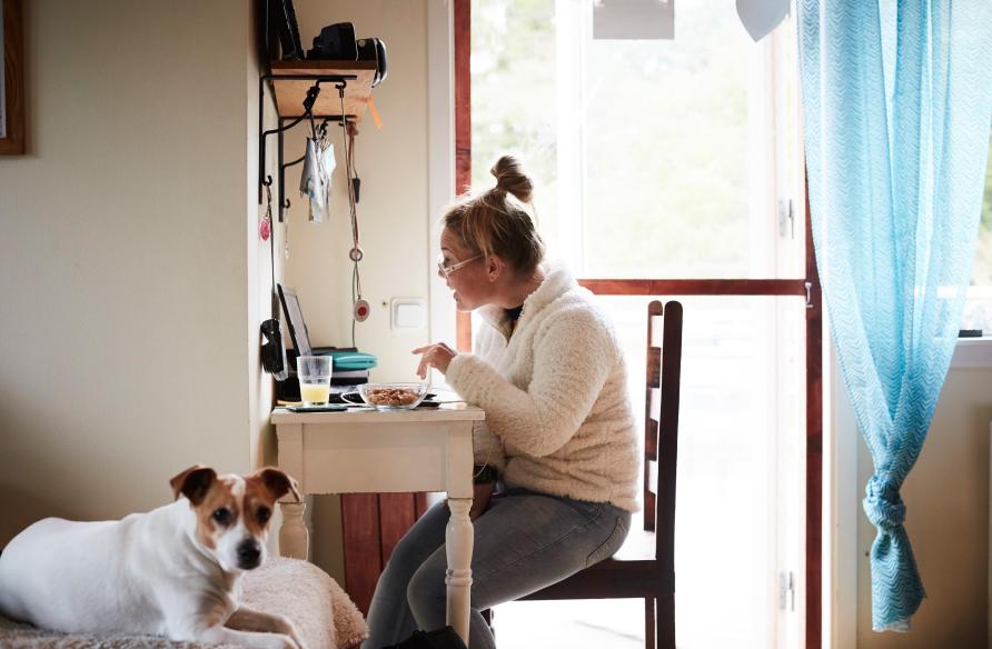 Young person working at a laptop at a desk in their home