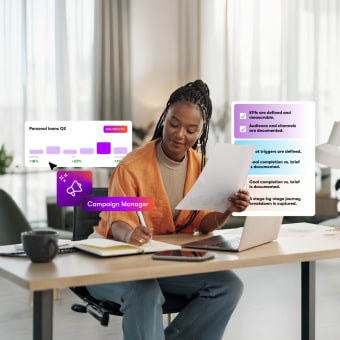 A woman works at a desk with a laptop and notebook, surrounded by floating digital charts and data.